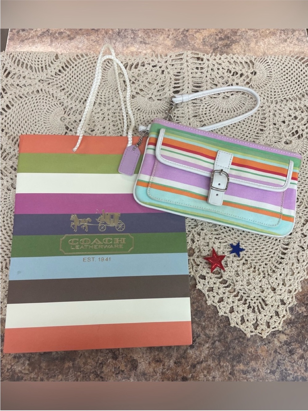 Coach Hampton striped wristlet with her Coach gift bag.
